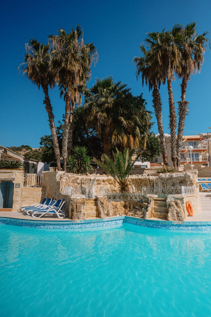 ppool with palm trees at Xemxija Bay Hotel in Malta